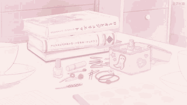a stack of books sits on a table next to a pink box