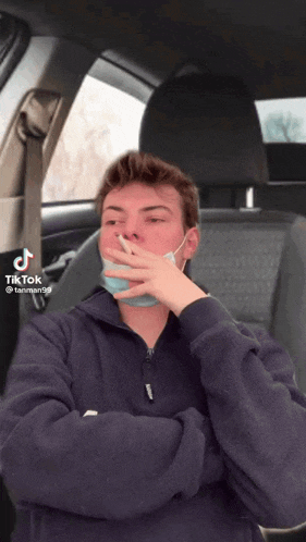 a man wearing a face mask is smoking a cigarette