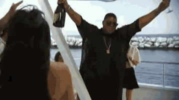 a man is holding a bottle of champagne in the air while a woman looks on