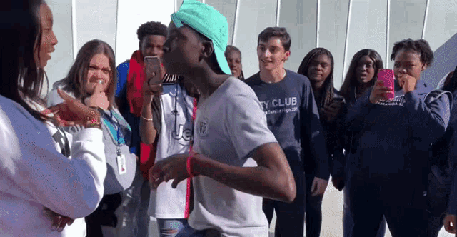 a group of young people are gathered around a man wearing a shirt that says city club