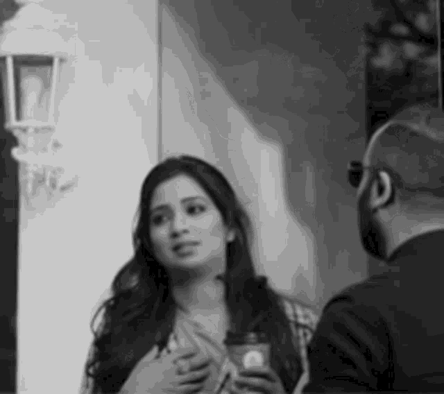 a man and a woman are standing next to each other in a black and white photo .