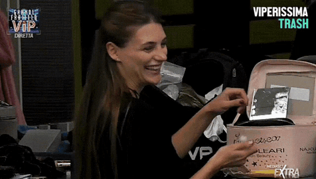 a woman is smiling while holding a pink bag that says vip on it