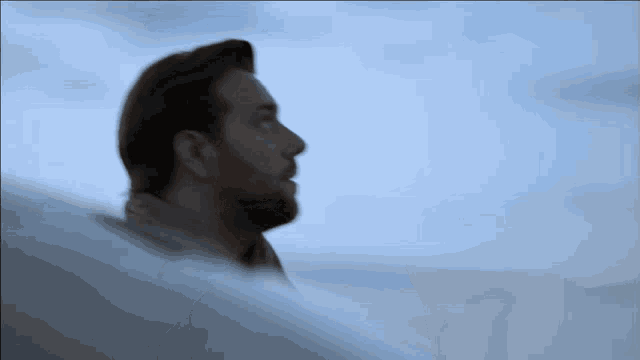 a man with a beard is looking up at something