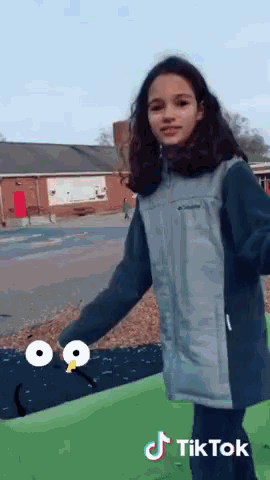 a girl in a columbia jacket is standing in front of a building