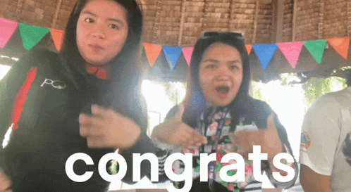 two women are standing next to each other with the word congrats in front of them
