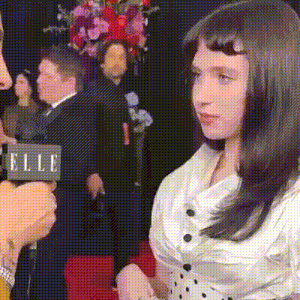 a woman is being interviewed by a man with a sign that says elle in the background
