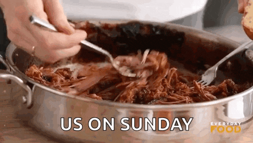 a person is cooking pulled pork in a pan with a fork and spoon .