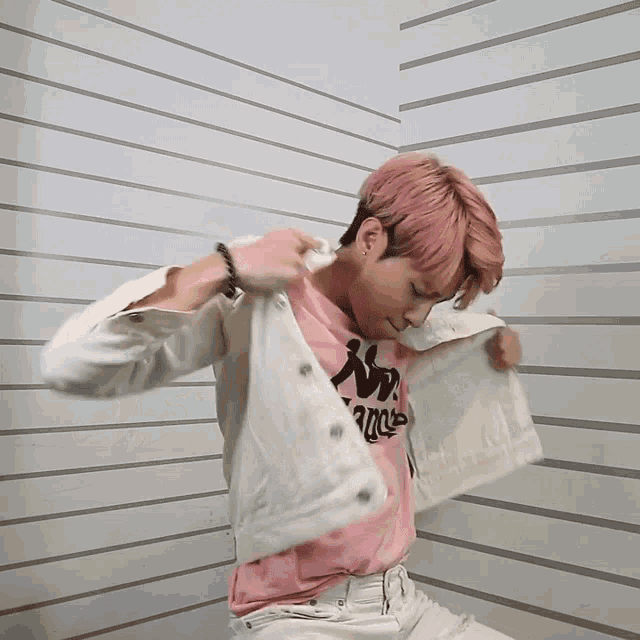 a man with pink hair is wearing a kappa t-shirt