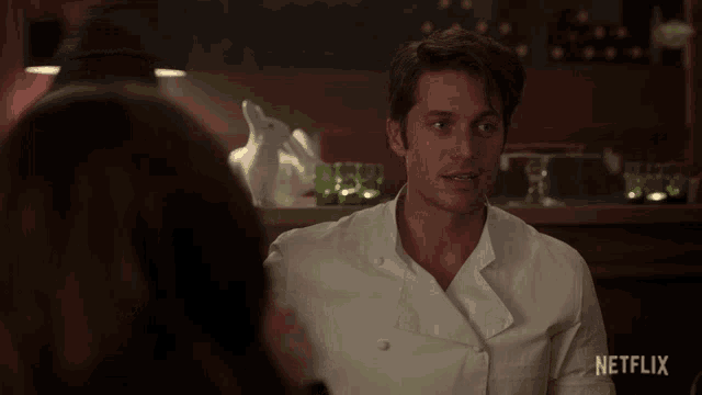 a man in a chef 's uniform is talking to a woman in a netflix advertisement