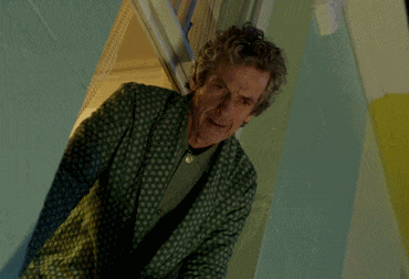 a man in a green polka dot robe stands in a doorway