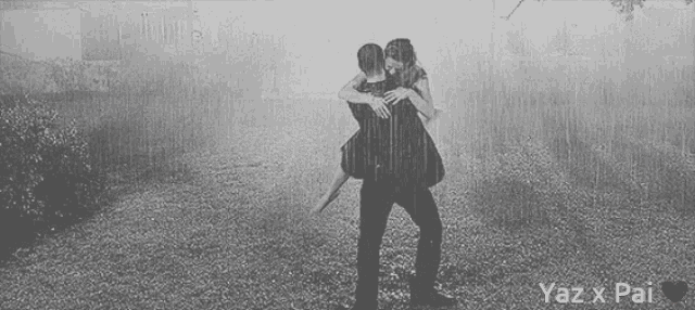 a black and white photo of a man carrying a woman in his arms with yaz x pai written on the bottom