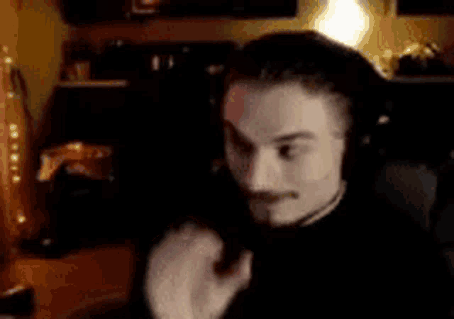 a man wearing headphones is sitting in front of a computer monitor .