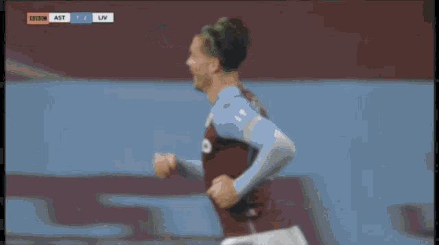 a blurred image of a soccer player celebrating a goal with the score ast 2 liv