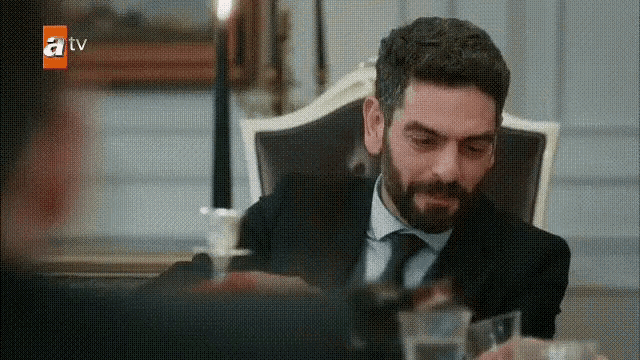 a man in a suit and tie is sitting in a chair .