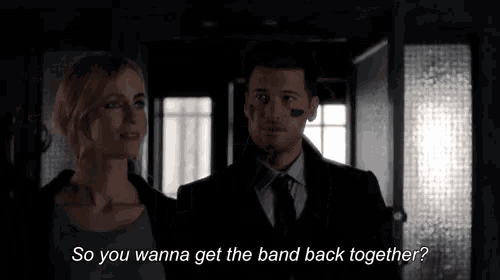 a man and a woman are standing next to each other and the man is asking the woman if she wants to get the band back together