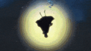 a silhouette of a person floating in the air with a yellow light behind them