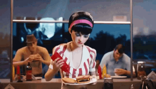 a woman is holding a plate with a hamburger on it