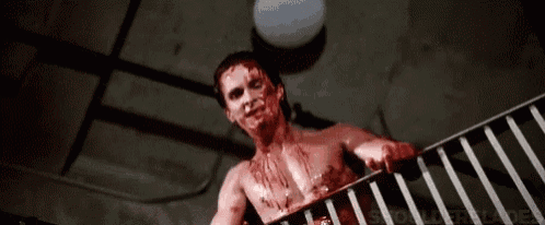 a shirtless man with blood on his face is standing on a balcony .