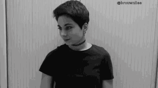 a black and white photo of a woman with short hair wearing a choker .