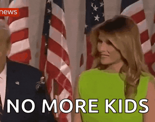 a woman in a green dress stands in front of american flags and says no more kids .