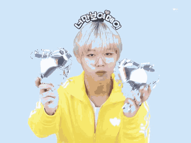 a boy wearing glasses and a yellow jacket is holding a heart shaped balloon with the word love on it