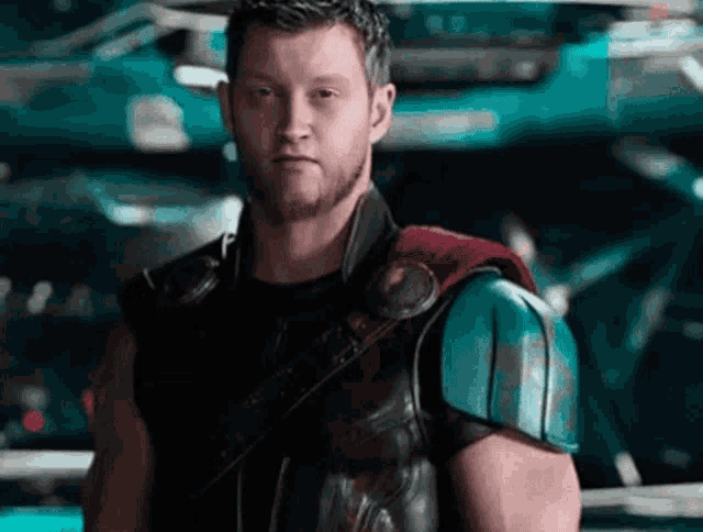 a man in a superhero costume is standing in front of a car .