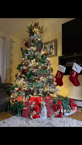 a christmas tree in a living room with stockings and presents