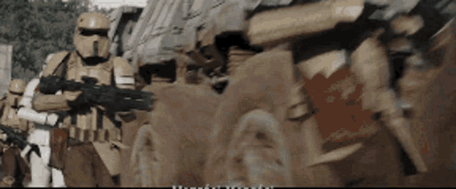 a group of storm trooper soldiers are standing in a line holding guns .