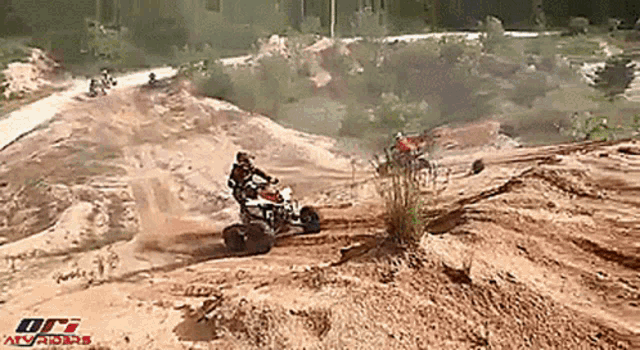 a man riding a four wheeler on a dirt road with the word atvriders in the corner