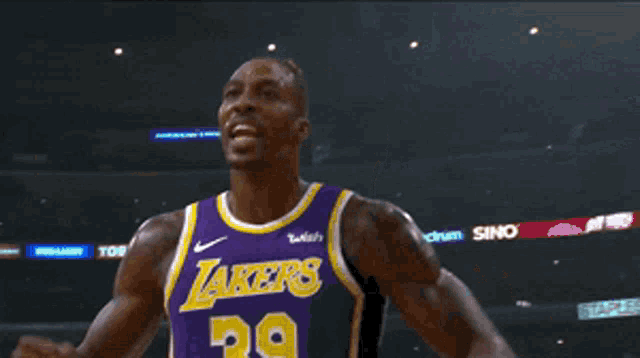 a basketball player in a lakers jersey looks up at the sky