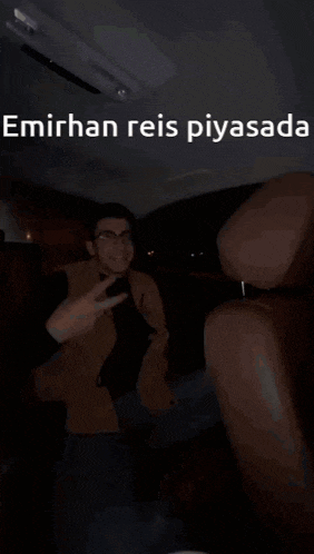 a man giving the middle finger in a car with the words emirhan reis piyasada below him