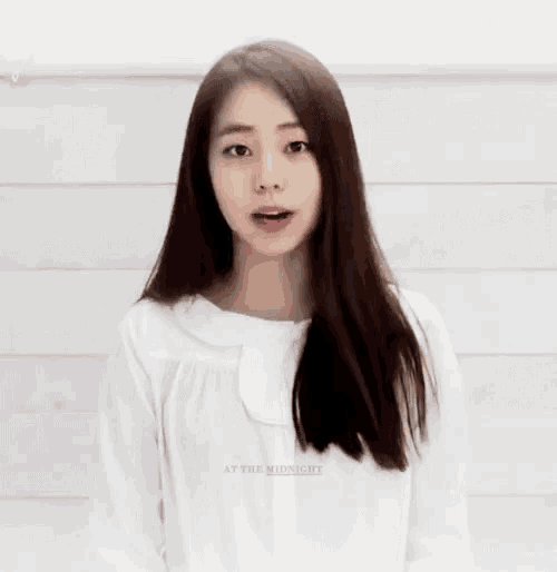 a woman wearing a white shirt that says at the midnight on it