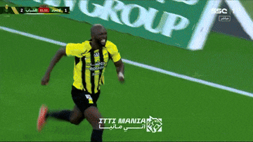 a man in a yellow and black striped shirt is running on a field