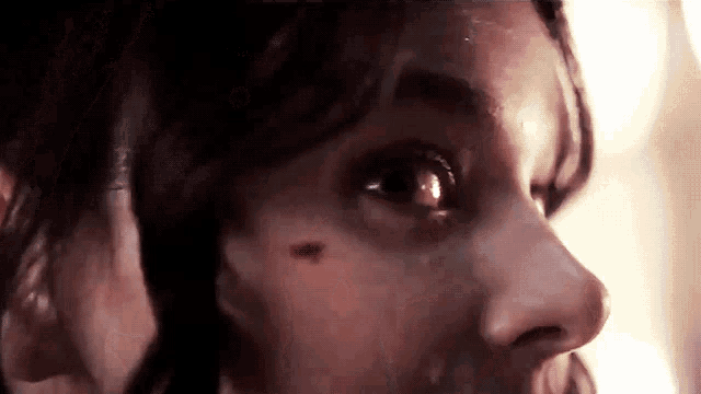 a close up of a woman 's face with a tear running down her cheek