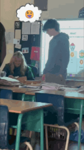 a boy and a girl are standing in a classroom with a thought bubble with a smiling face on it