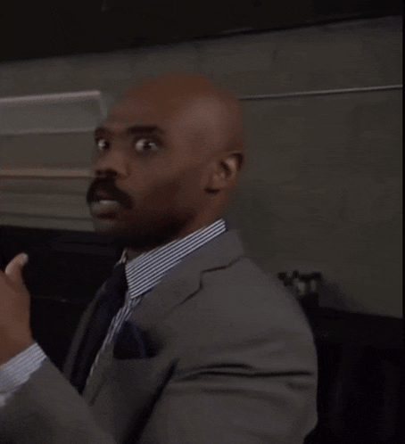 a bald man in a suit and tie is talking to a woman