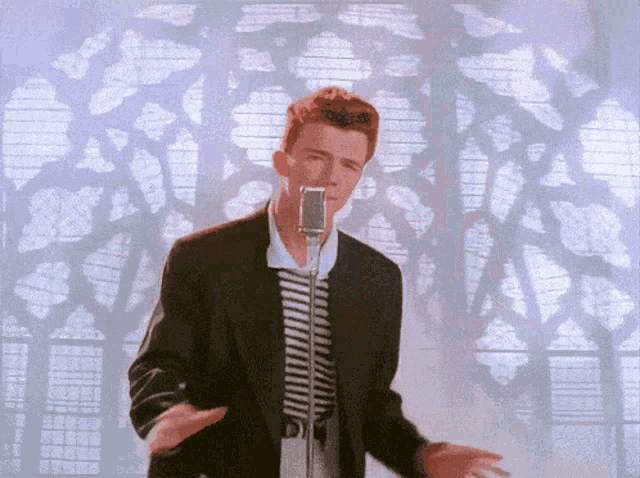 a man singing into a microphone in front of a stained glass window