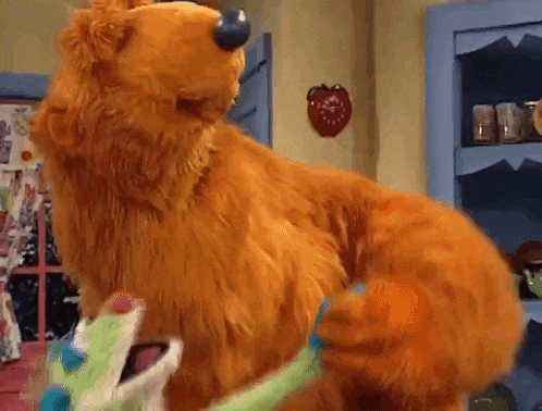 a stuffed bear is standing on its hind legs in a room .