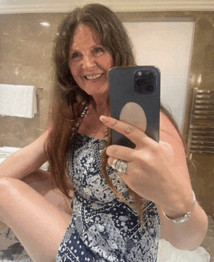 a woman in a blue and white dress is taking a selfie