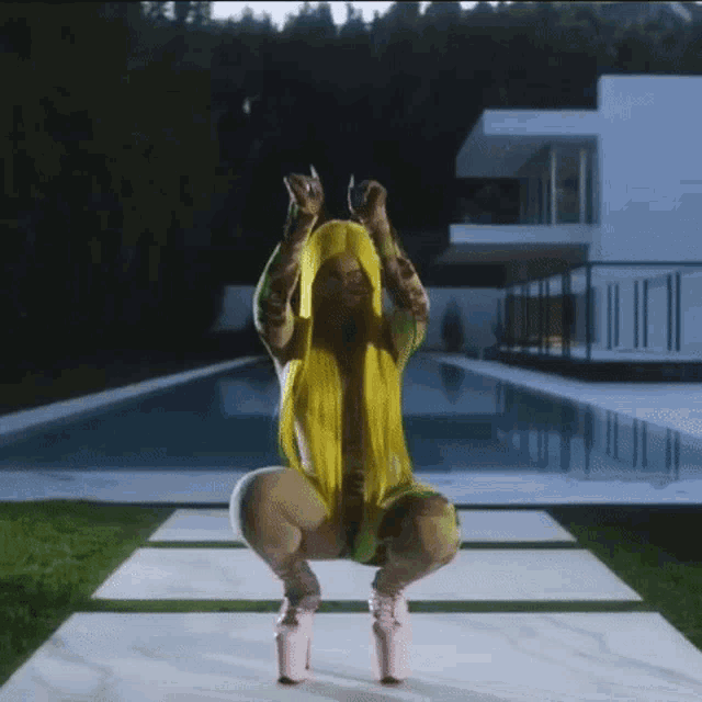 a woman with yellow hair is squatting in front of a pool .