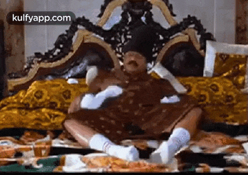 a person is sitting on a bed with their legs crossed and eating food .