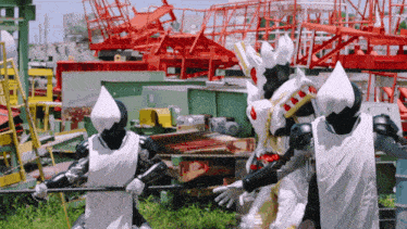 a group of superheros are standing in a field holding sticks