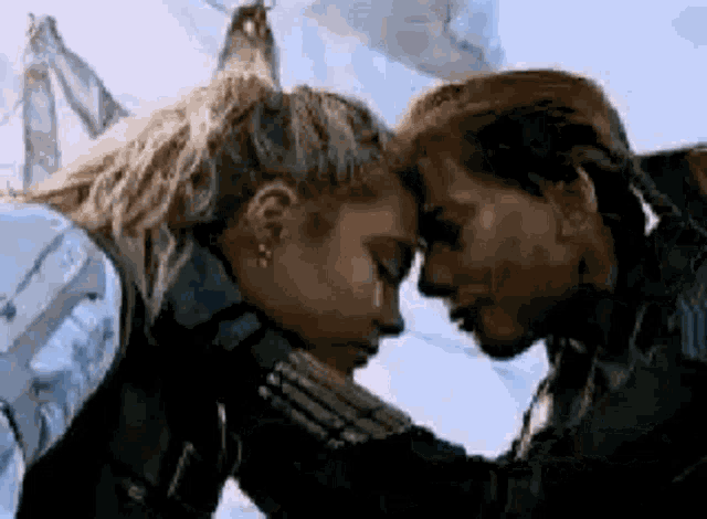 a couple of women are touching their foreheads .