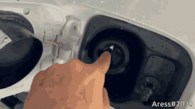 a person 's hand is pressing a button on the side of a car that says ' aress # 2030 '