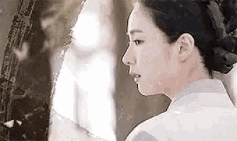 a woman is looking at herself in a mirror .