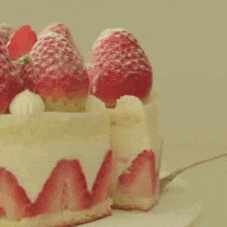 a close up of a strawberry cake with strawberries and whipped cream on a plate .