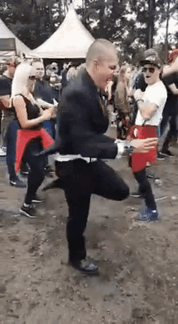 a man in a suit is dancing in a crowd