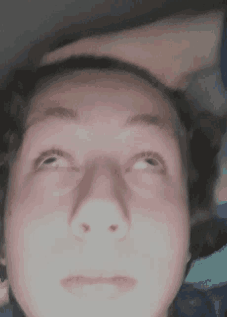 a close up of a person 's face with a hand on their forehead
