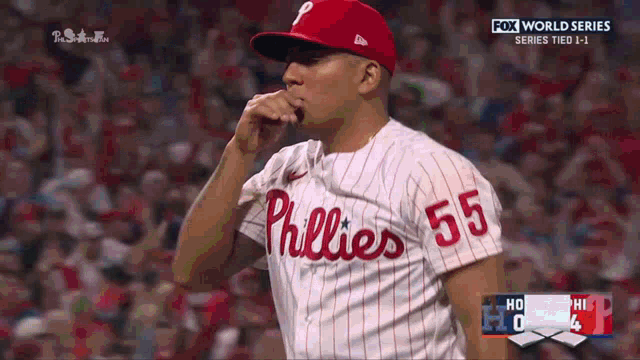 a phillies pitcher is blowing his nose during a game