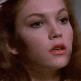 a close up of a woman 's face with a slight smirk on her face .